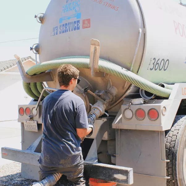 Man hooking up pumping line to truck